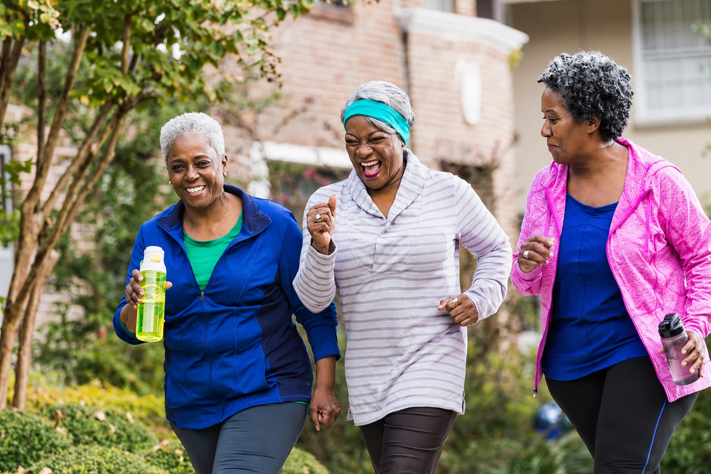 Three women walking together outside in athletic clothing